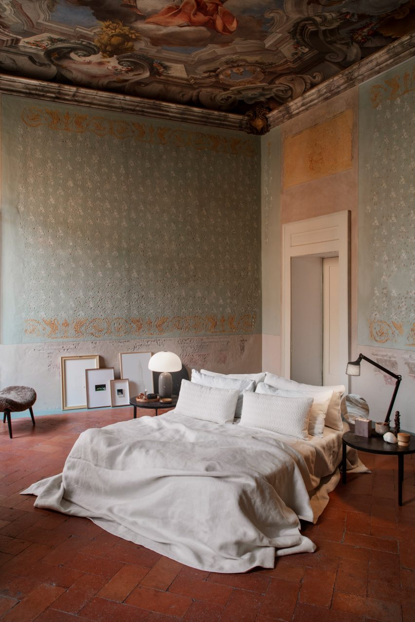 Bed on red-tiled floor of Palazzo Monti