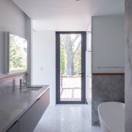 Bathroom interior with grey stone units and a mosaic floor
