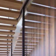 Timber floating staircase alongside a window with exterior timber slats