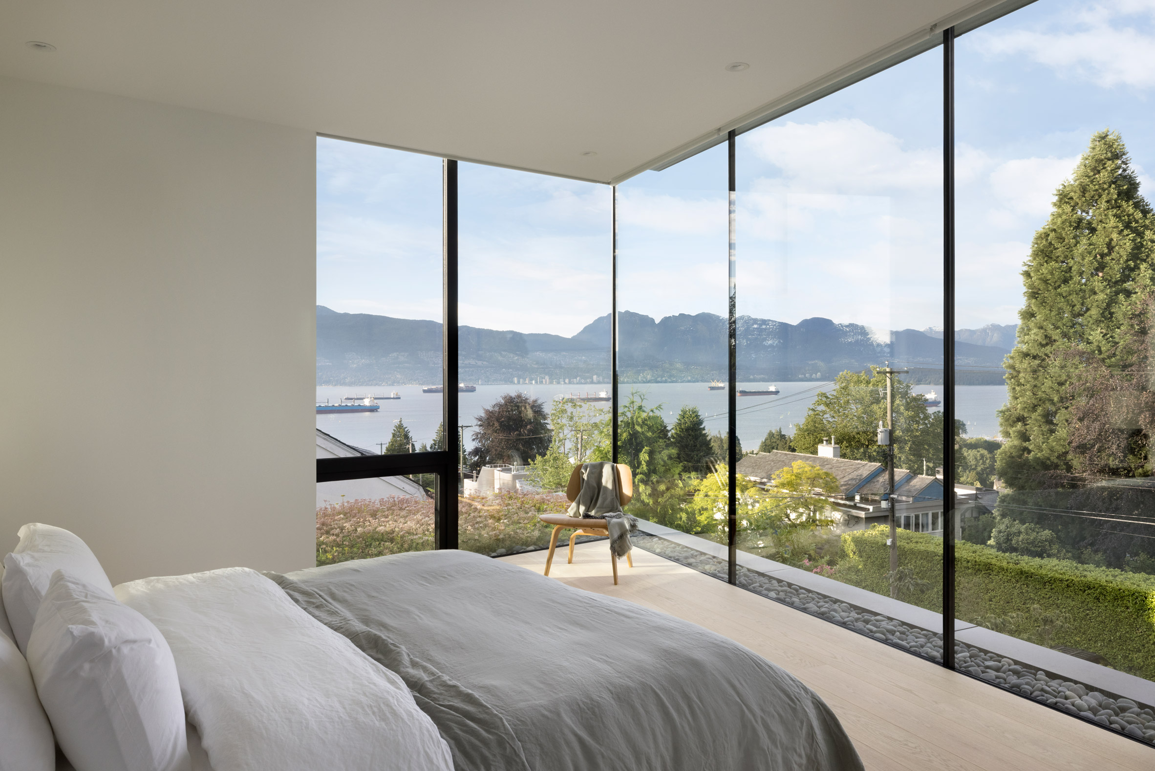 Glass walls within bedroom of house by Splyce Design