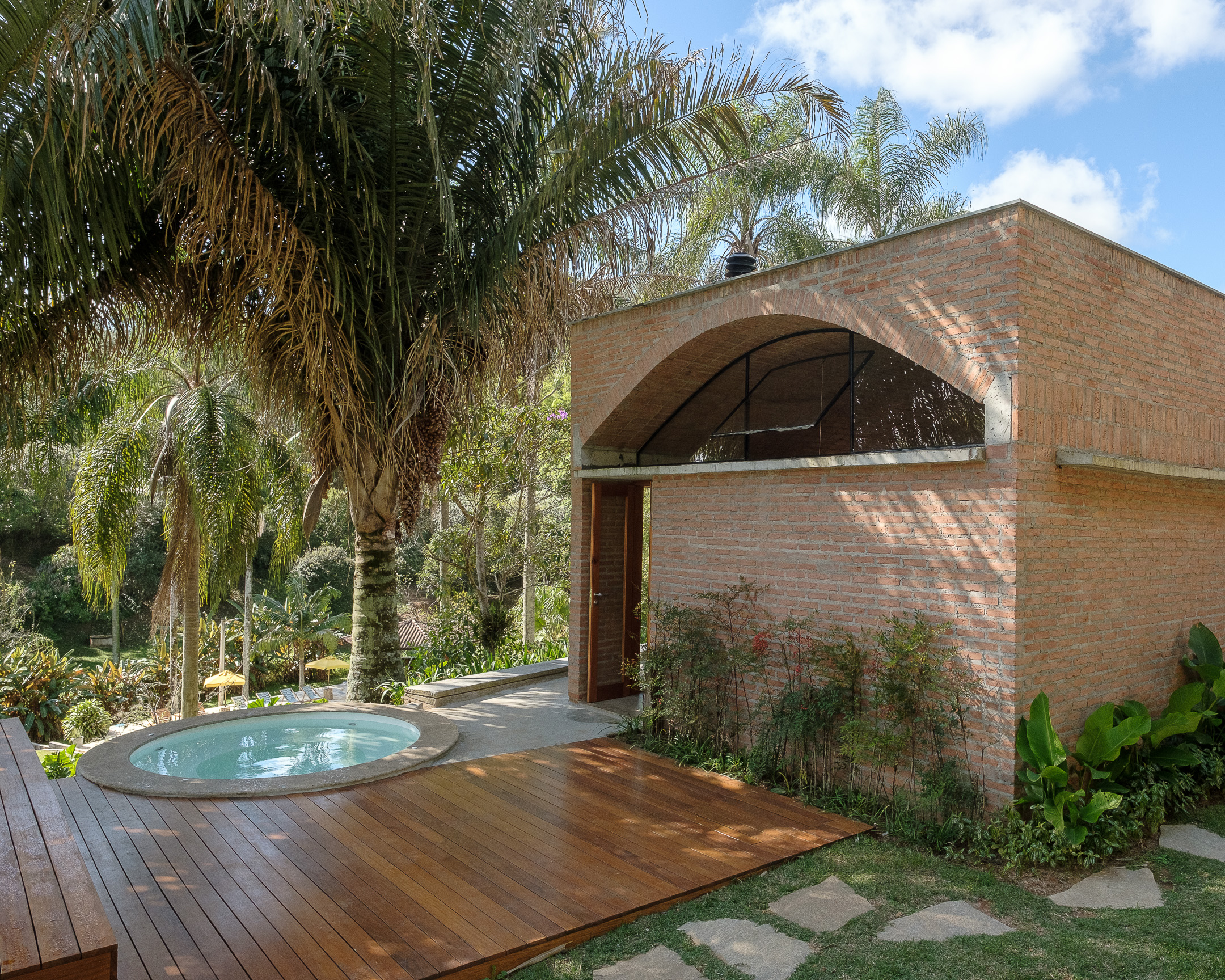 Brick cubed building with a ceramic vaulted ceiling next to a small plunge pool surrounded by decking