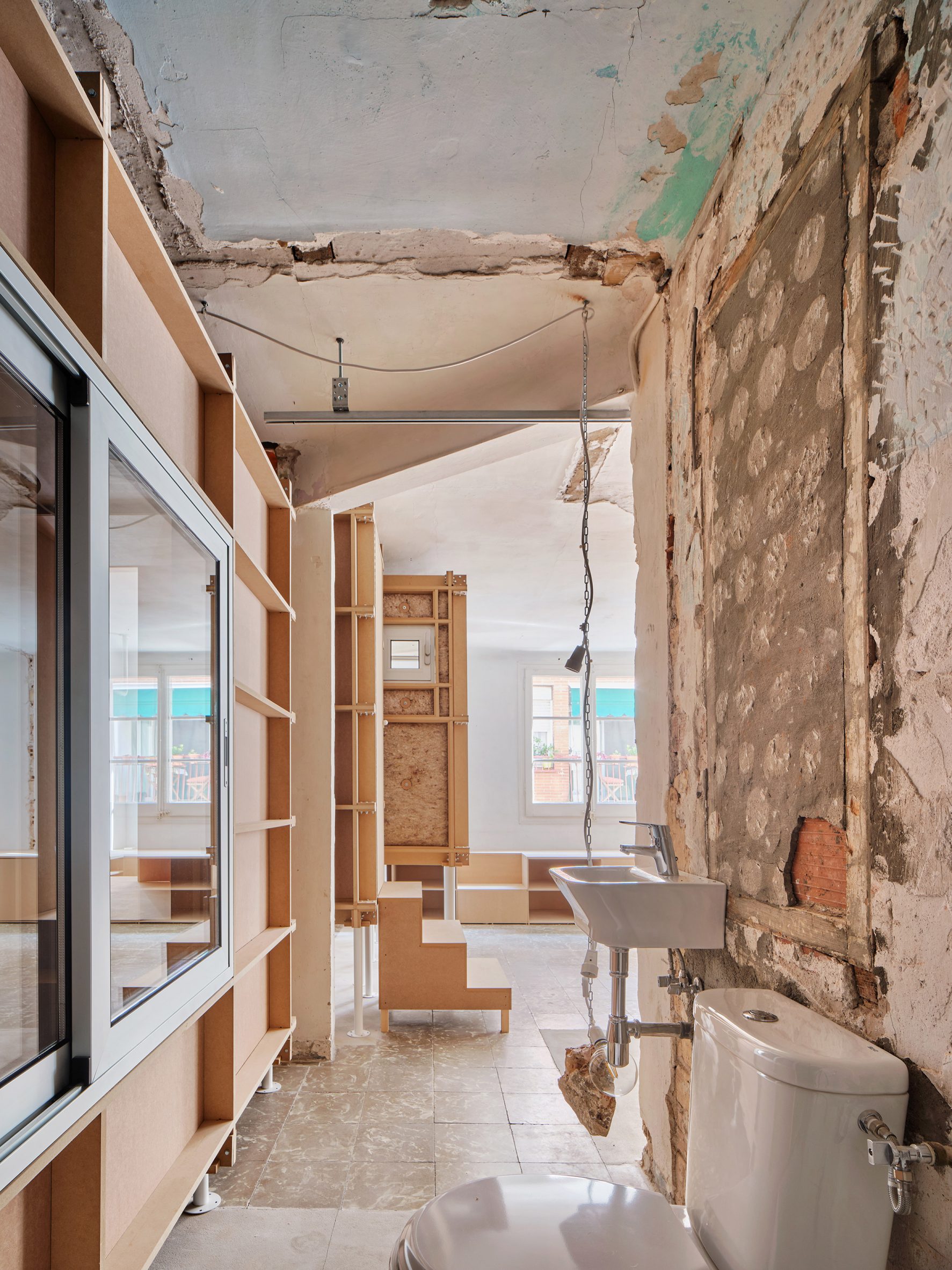 Exposed wall and white toilet within 10K House by Takk