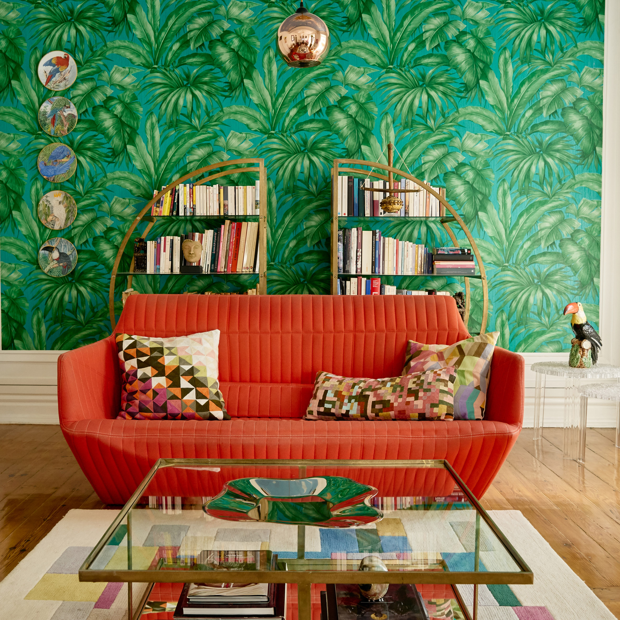 Interior featuring plant wallpaper and orange sofa