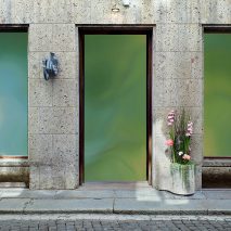 Photo of a building with green windows and flowers