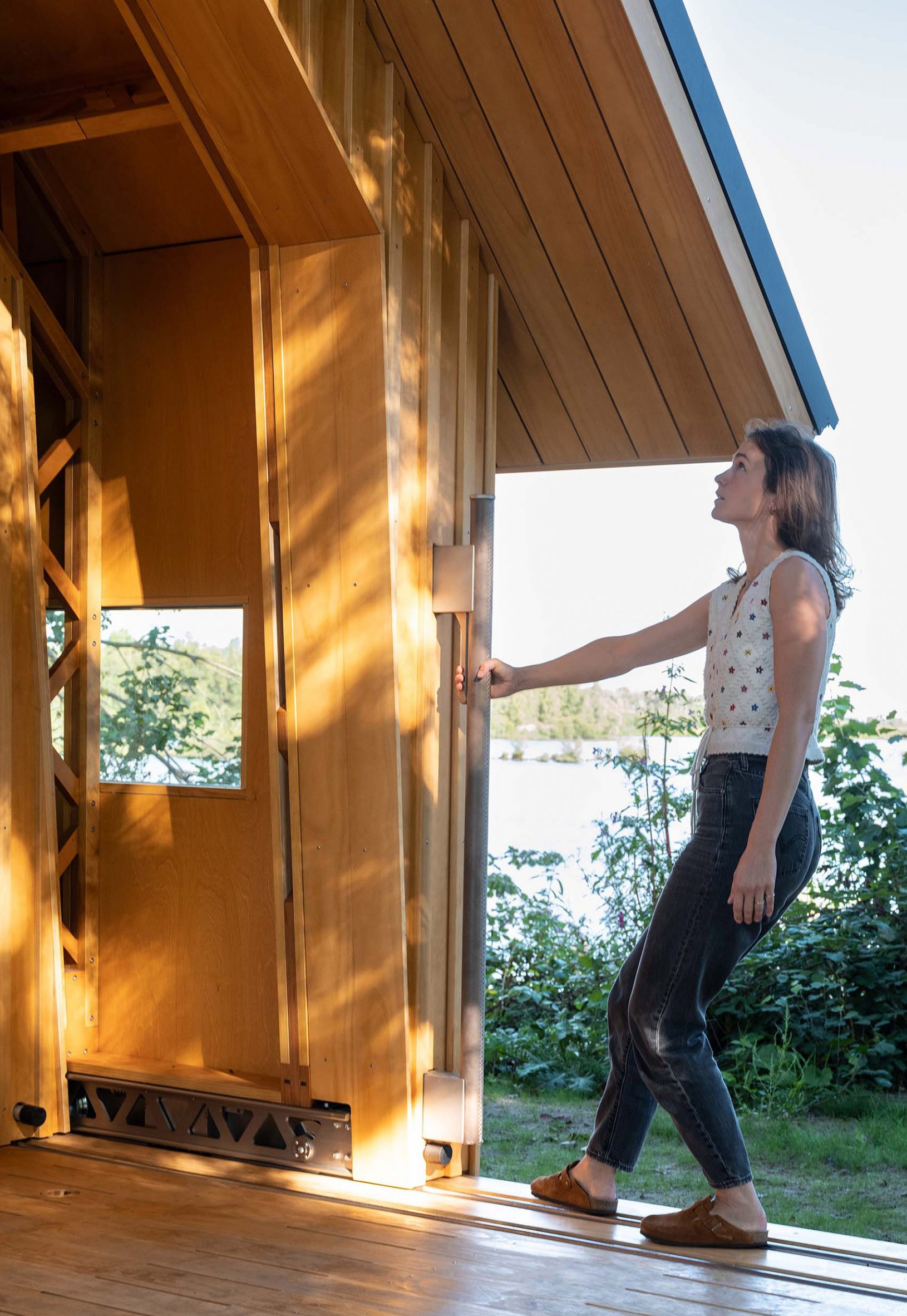 Woman sliding walls of Cabin Anna in the Netherlands by Caspar Schols