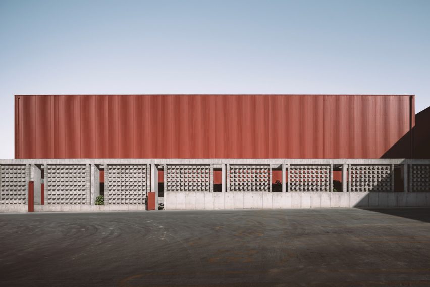 Red volumes with grey concrete elements on sunny site in Mexico