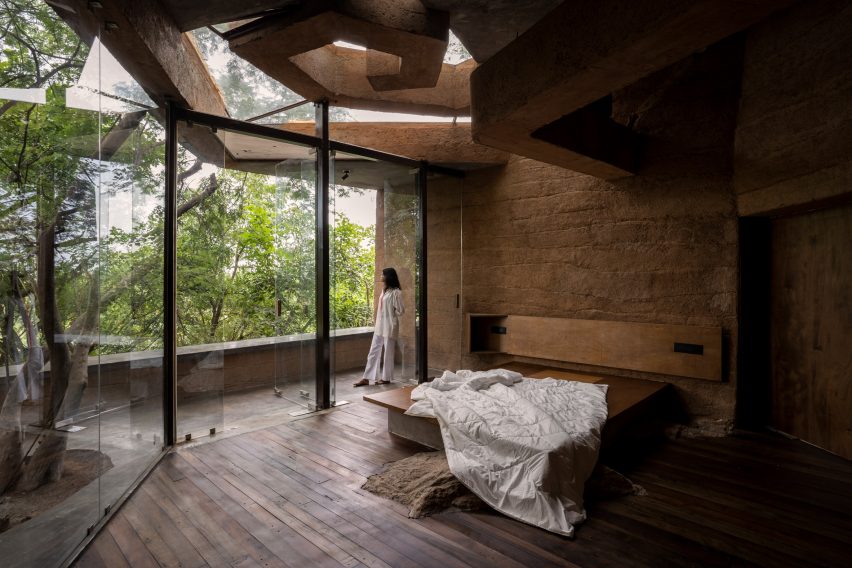 Dormitorio con abertura vidriada y paredes de adobe