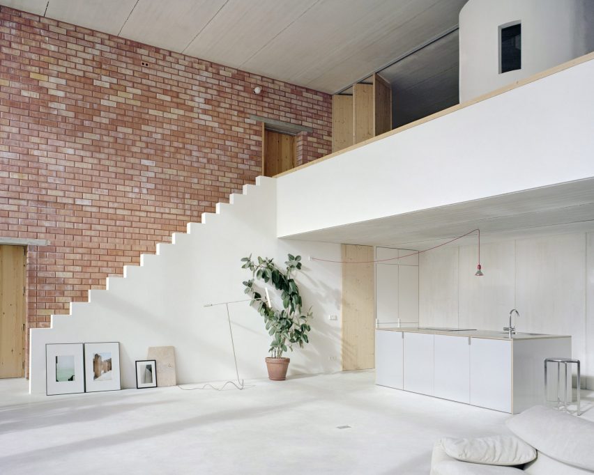 Interior of brick and concrete living room by Mesura