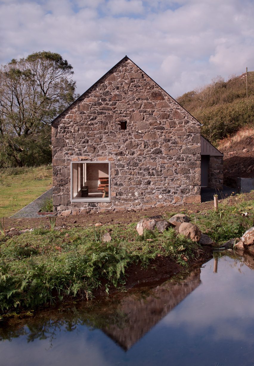 Stone-clad gabled renovated barn with rectilinear window