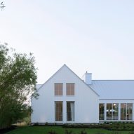 A white house with a gable end with windows in garden