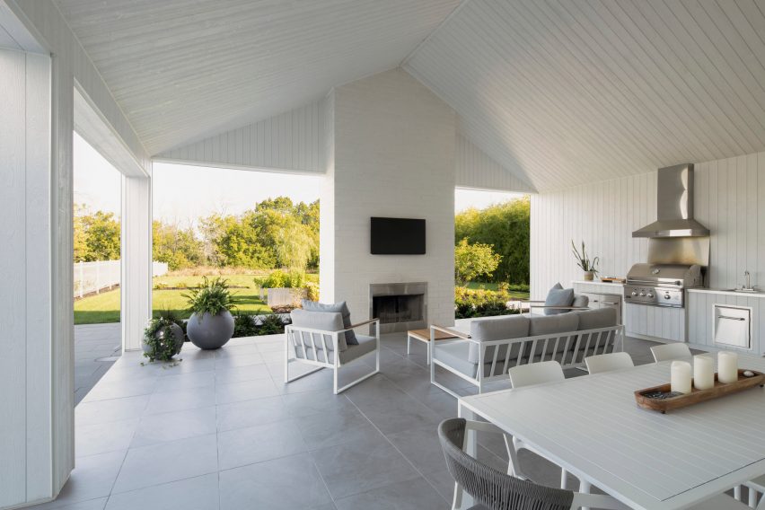 Sala de estar y comedor de planta abierta en una terraza con pisos grises y techo blanco en lo alto