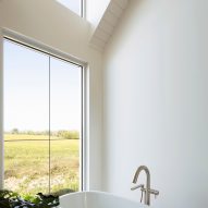 A bathroom with a freestanding bathtub and a window overlooking a garden