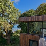 Top floor of a timber-clad home overlooking trees