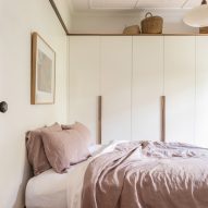 Bedroom with white cupboards and a bed with pink bedding