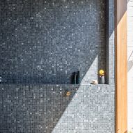 Bathroom with dark mosaic wall tiles and niche
