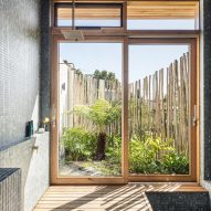 Bathroom with wood deck flooring and large windows overlooking a garden