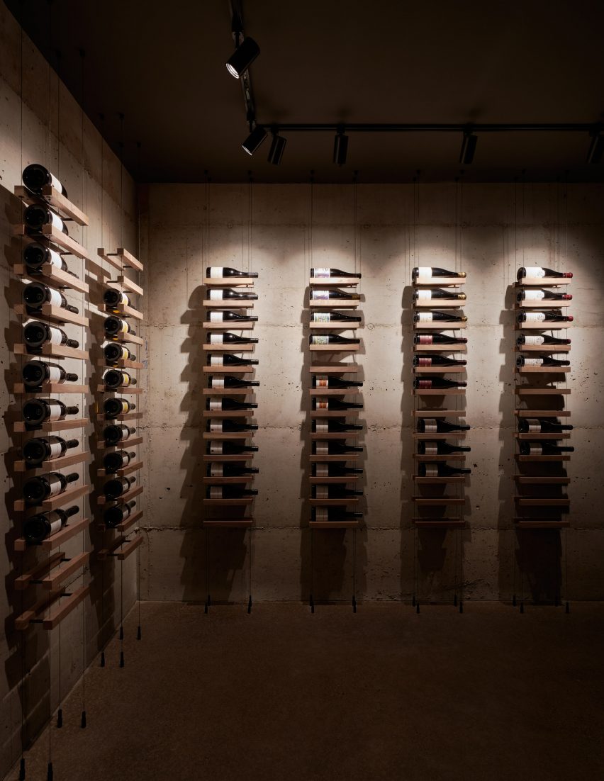 Low-lit wine cellar with shelving on wall