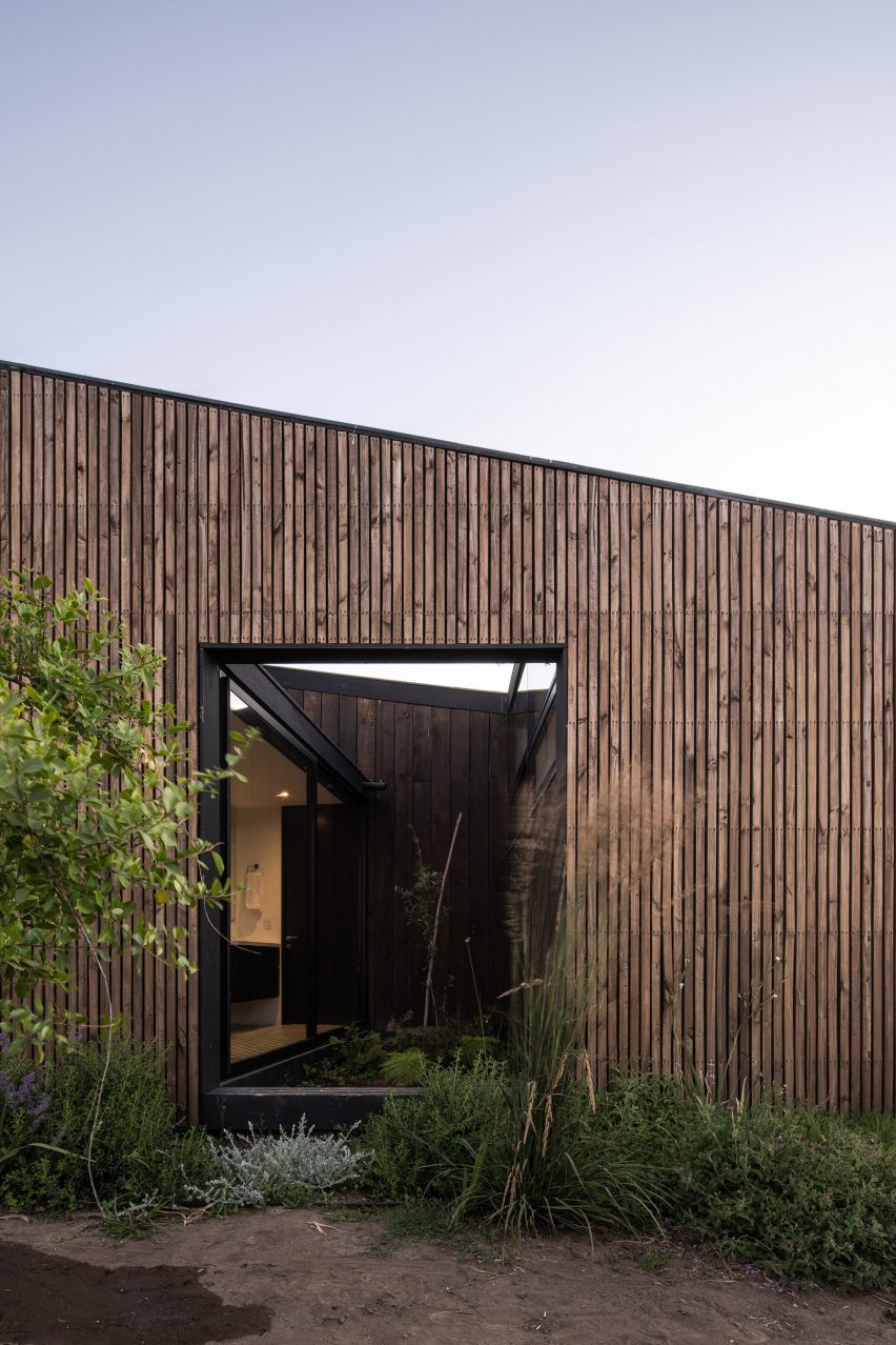 نمای بیرونی خانه چوبی با سقف شیبدار و دهانه مستطیل شکل