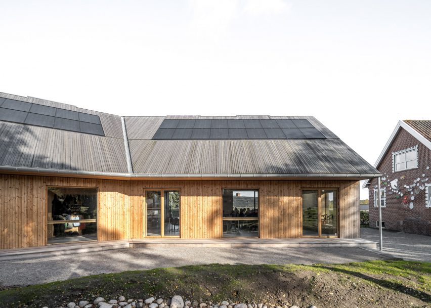 Edificio revestido de madera con paneles solares en el techo