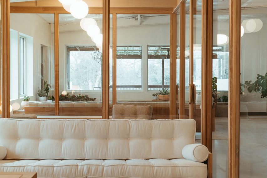 Beige sofa in front of glass-walled offices