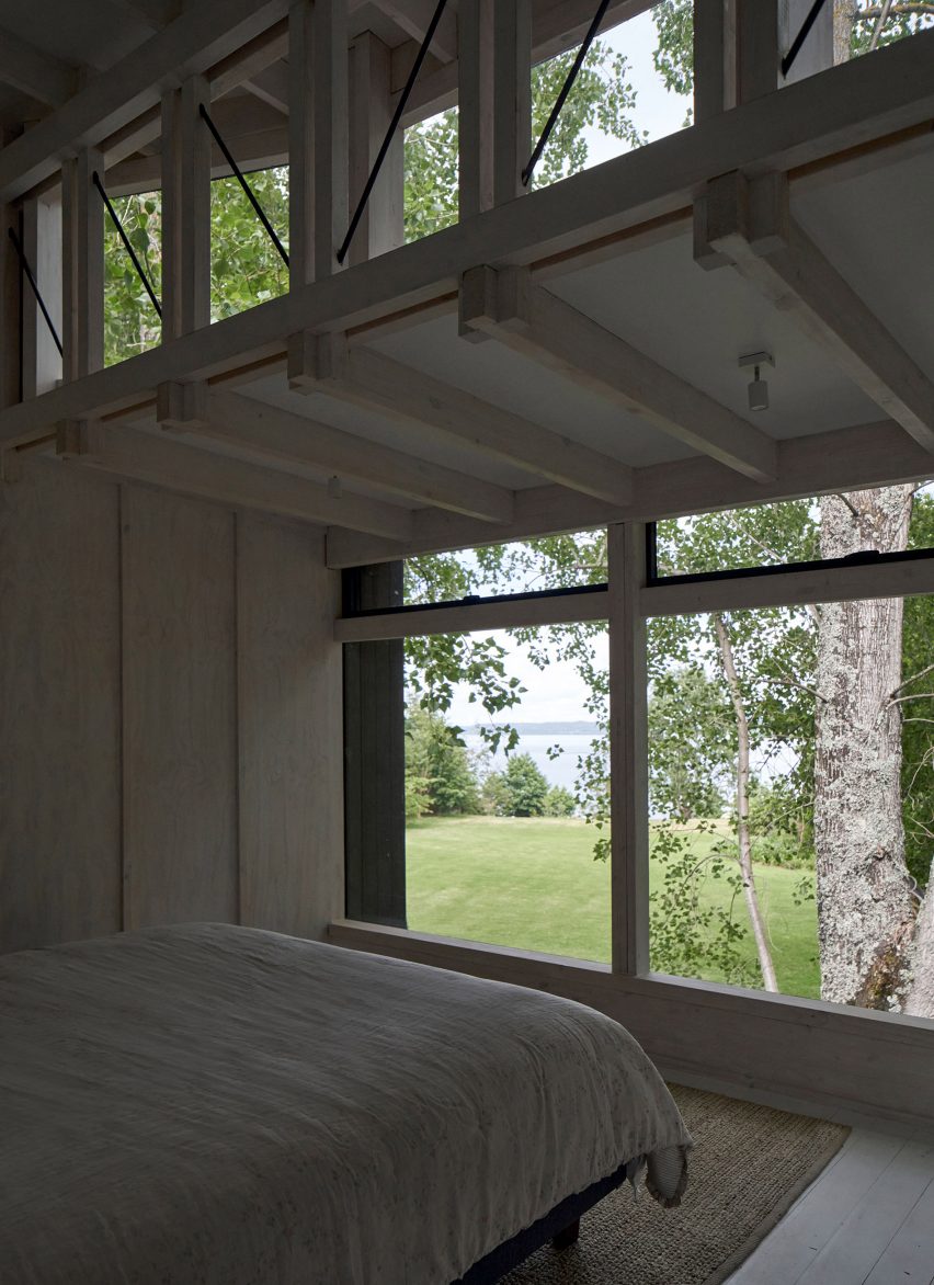 Large window with view of Chilean landscape next to a bed within house by Izquierdo Lehmann