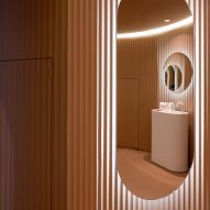 Peach ribbed wall panelling with an elogated backlit wall mirror