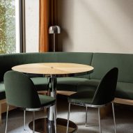 Restautant interior with green upholstered seating and wood tables