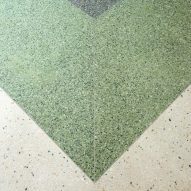 Terrazzo flooring in cream, green and deep green in a chevron pattern