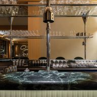 Restaurant bar with green marble countertop and stainless steel glass rack