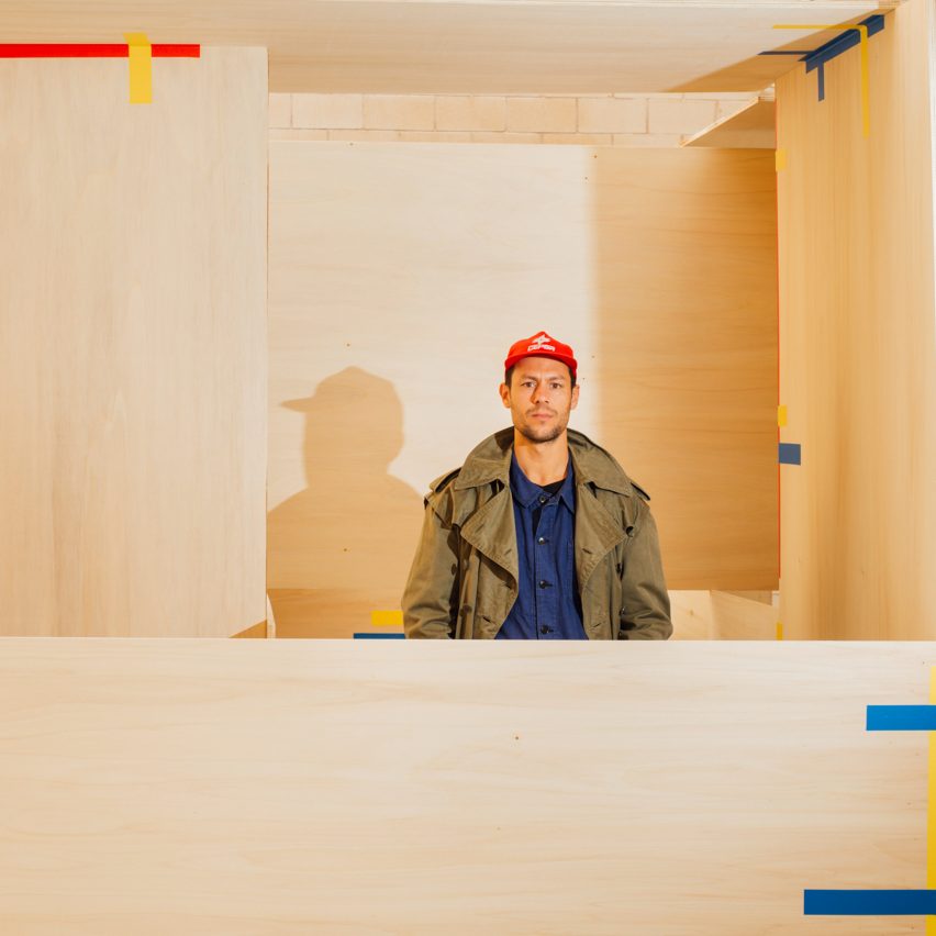 Jorge Penadés standing inside one of his Tape! pavilions made from plywood boards and tape