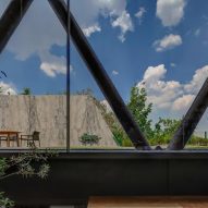 Large windows looking out to the exterior steel structure of a home and outdoor garden
