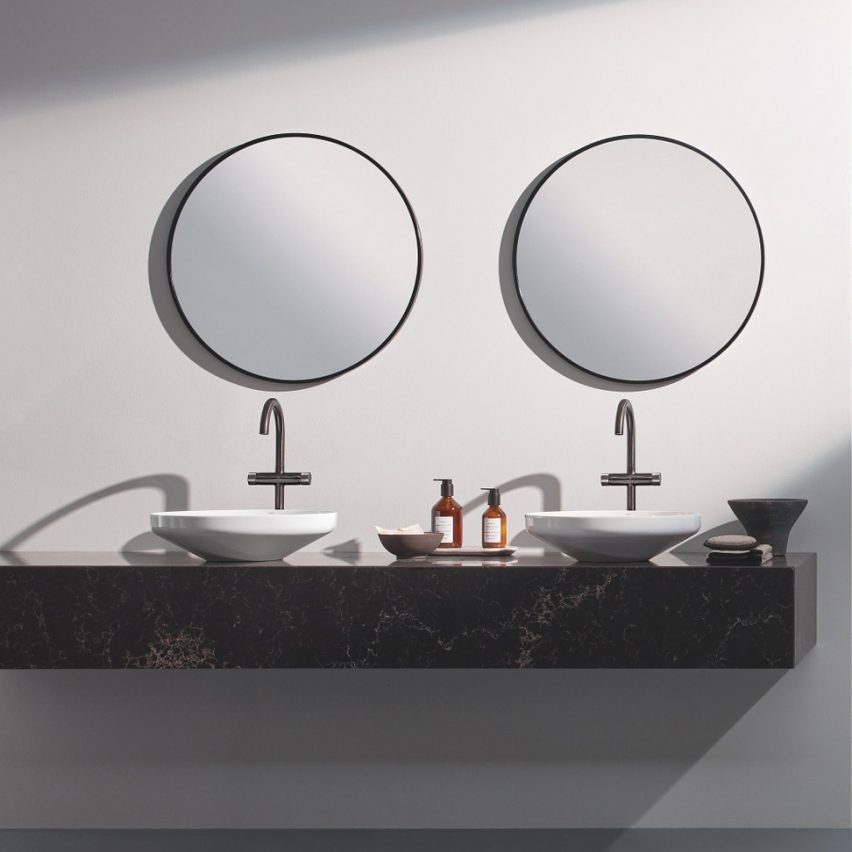 Two sinks below circular mirrors with silver hardware