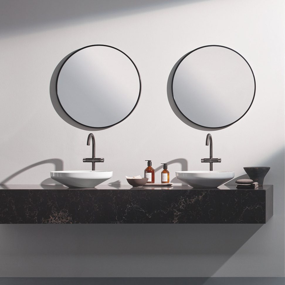 Two sinks below circular mirrors with silver hardware