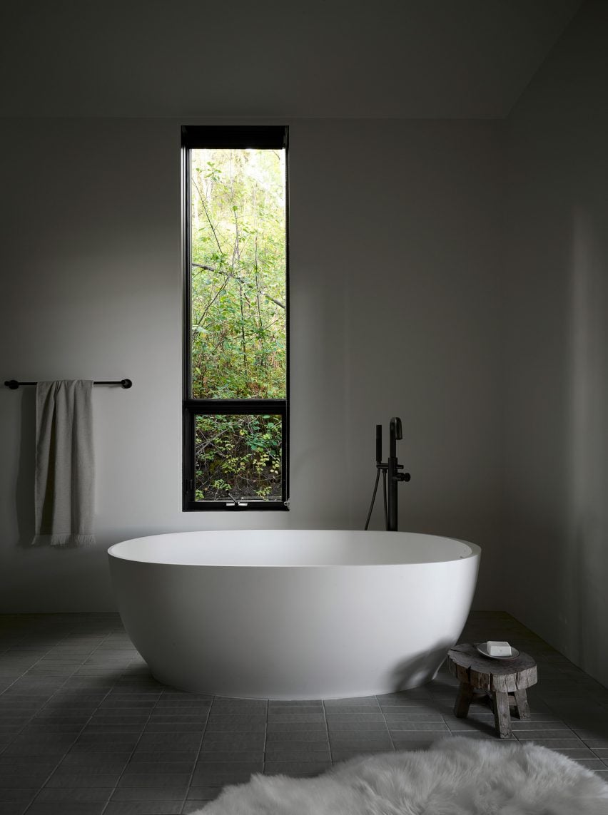Free-standing bathtub in grey-hued bathroom with rectilinear window