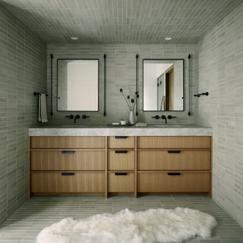 Quartzite vanity inside bathroom with stone-colored tiles