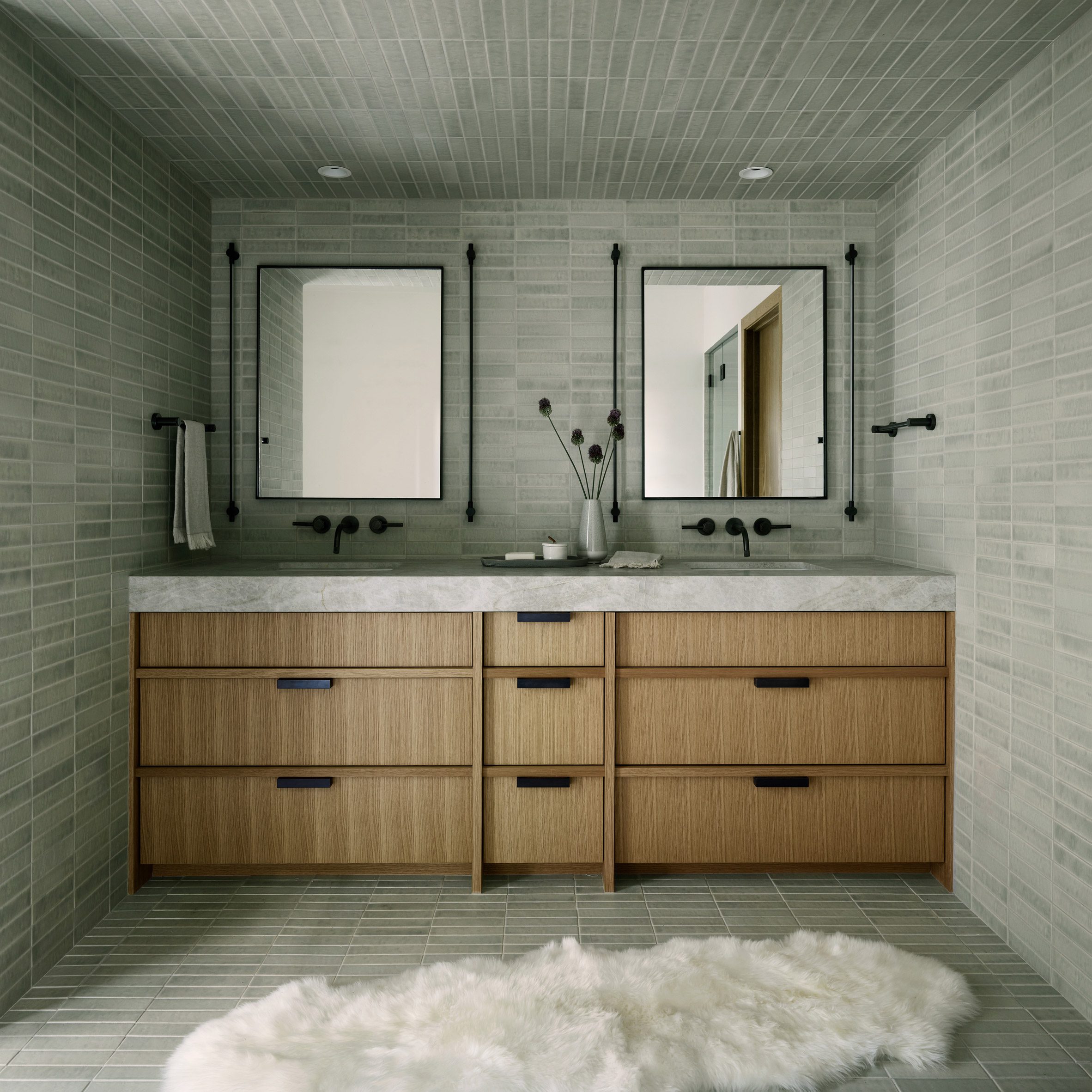 Quartzite vanity within bathroom with stone-hued tiles