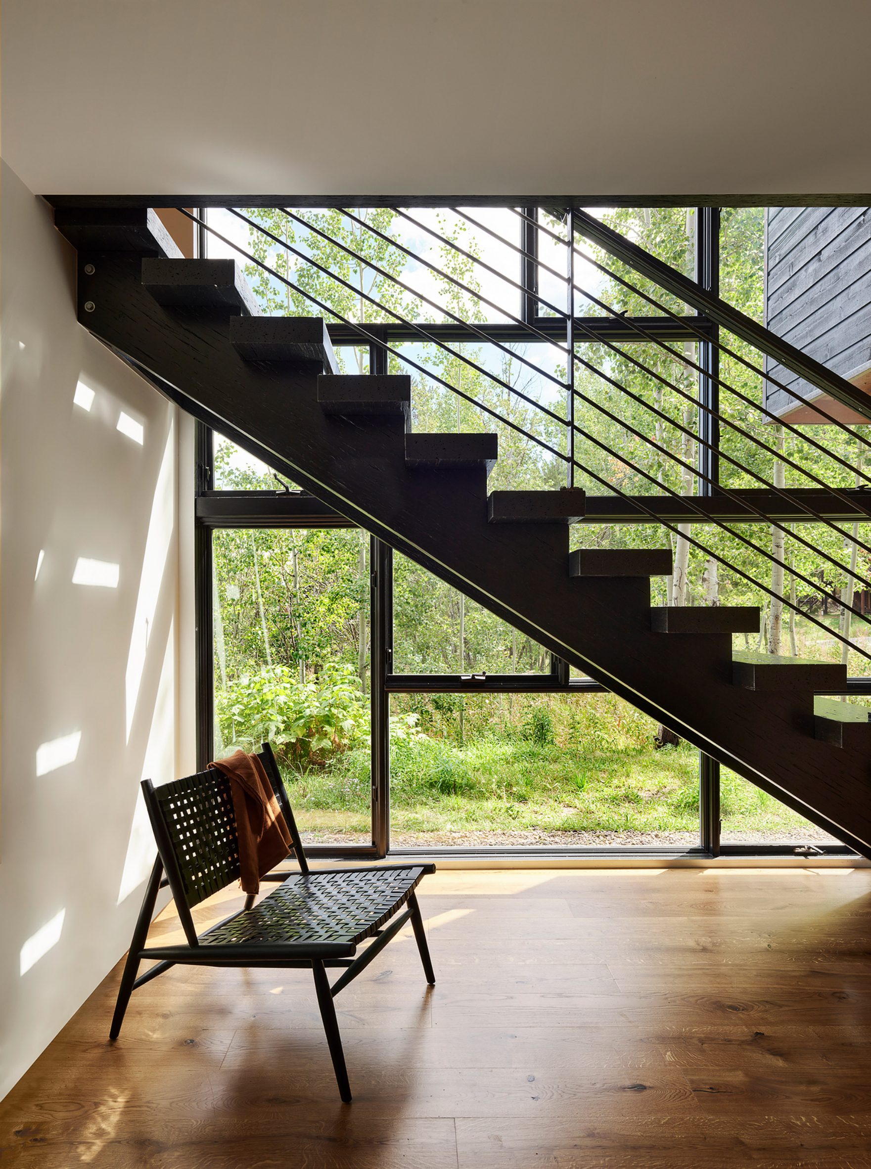Boxy staircase with geometric railing next to two-storey window