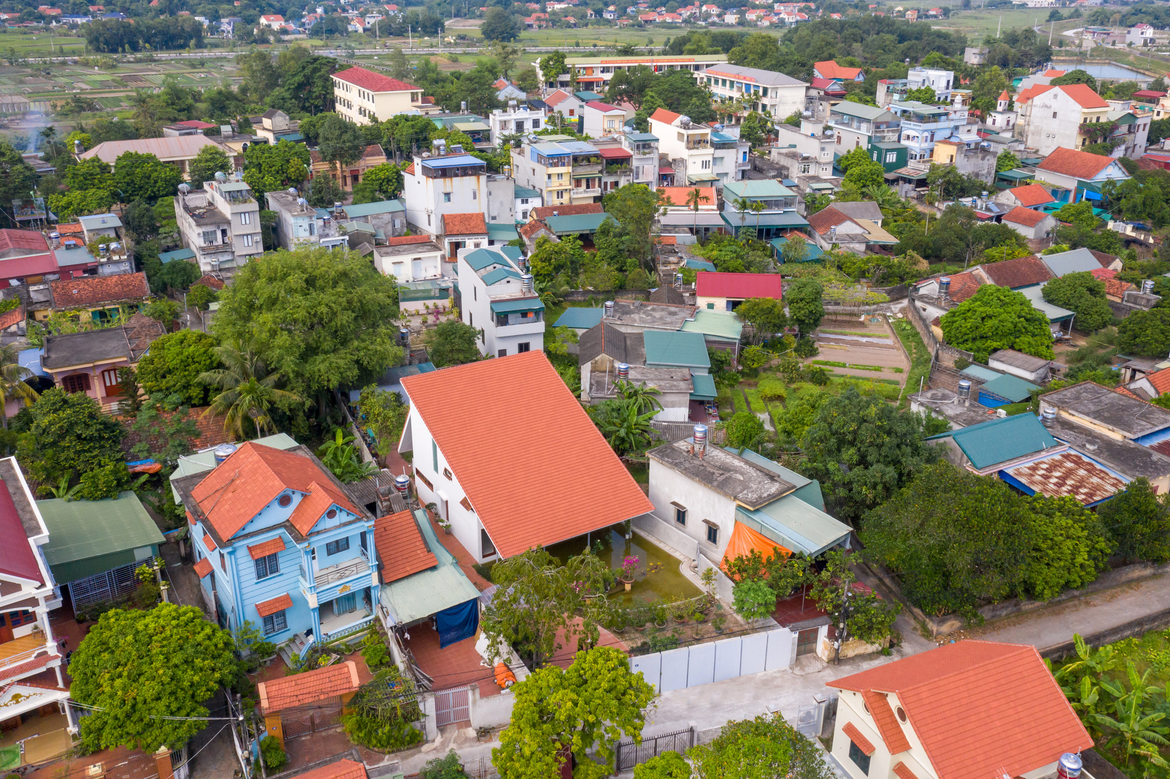 Aerial view of homes in Vietnam with lush green gardens and terracotta-tiled roofs