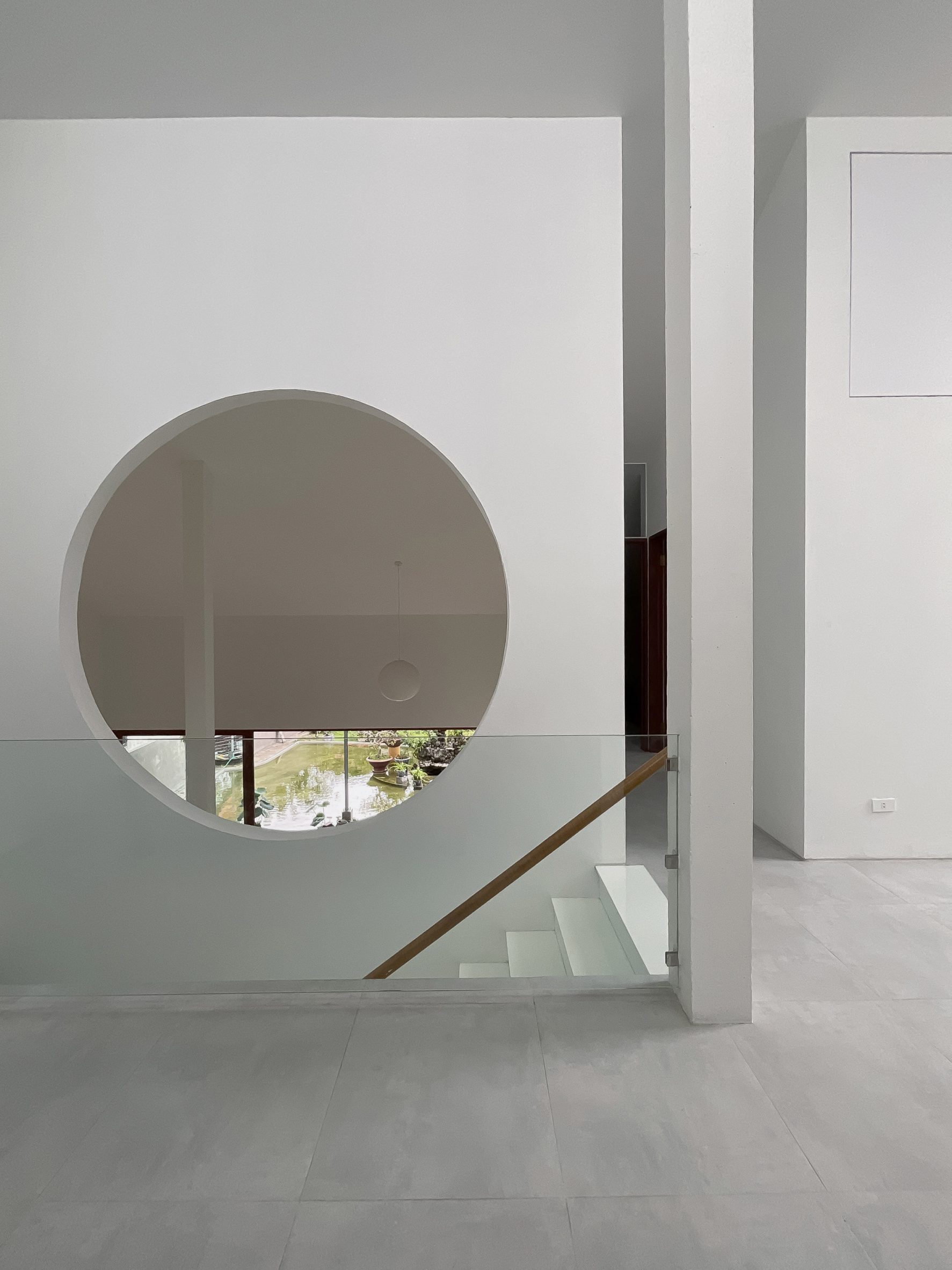 Interior space with white walls, a staircase and circular opening