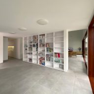 Interior space with concrete flooring, white walls and a built-in bookshelf