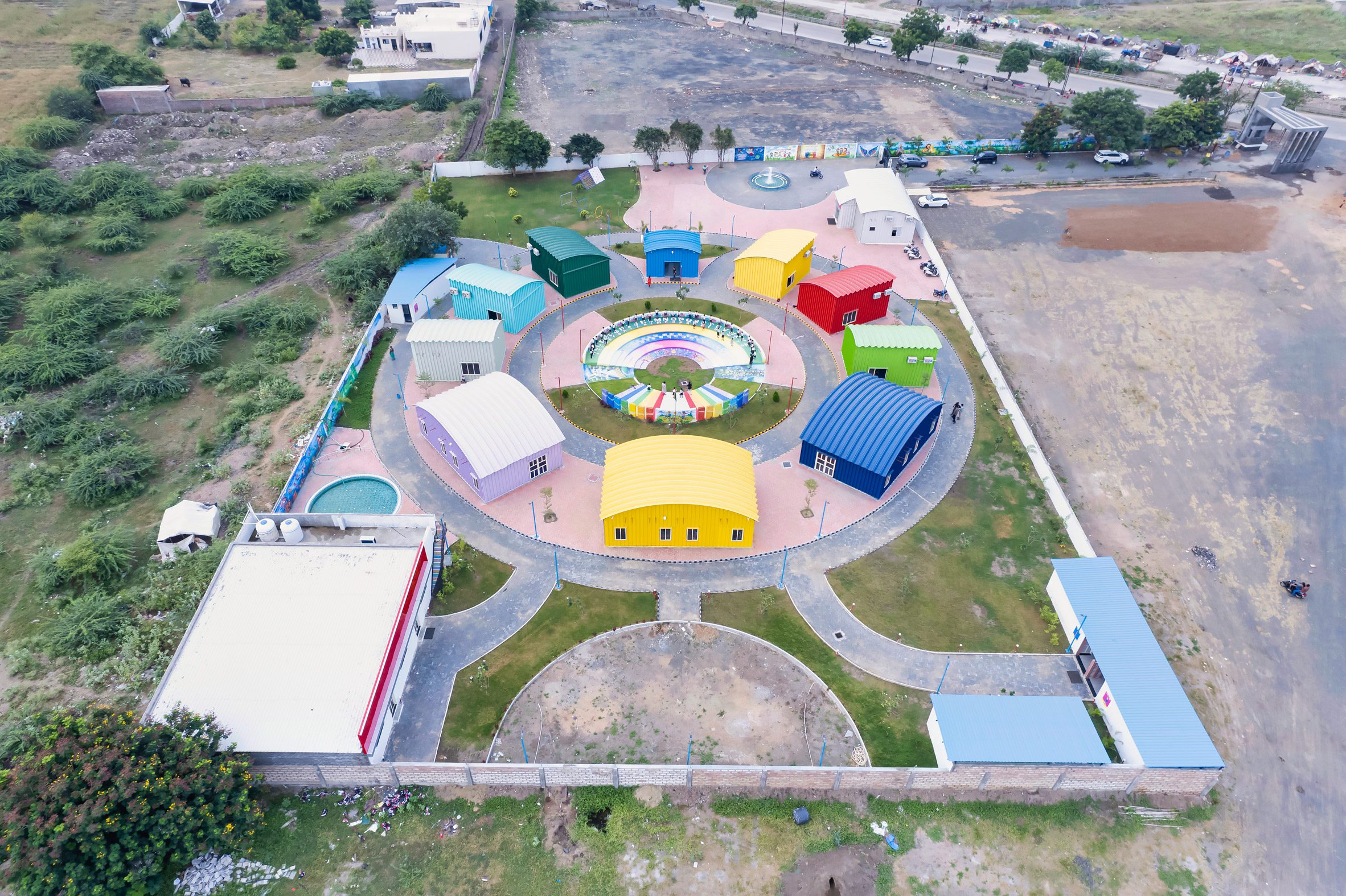 Colour steel classroom structures arranged in a circle around an amphitheatre