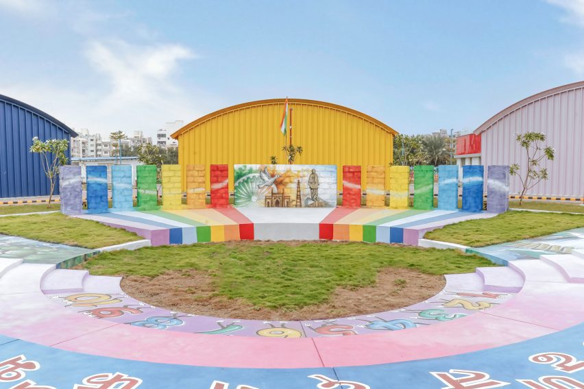 Colourful amphitheatre in grass surrounded by yellow, blue and pink structures