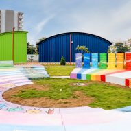 Colourful amphitheatre surrounded by green, blue and yellow steel buildings