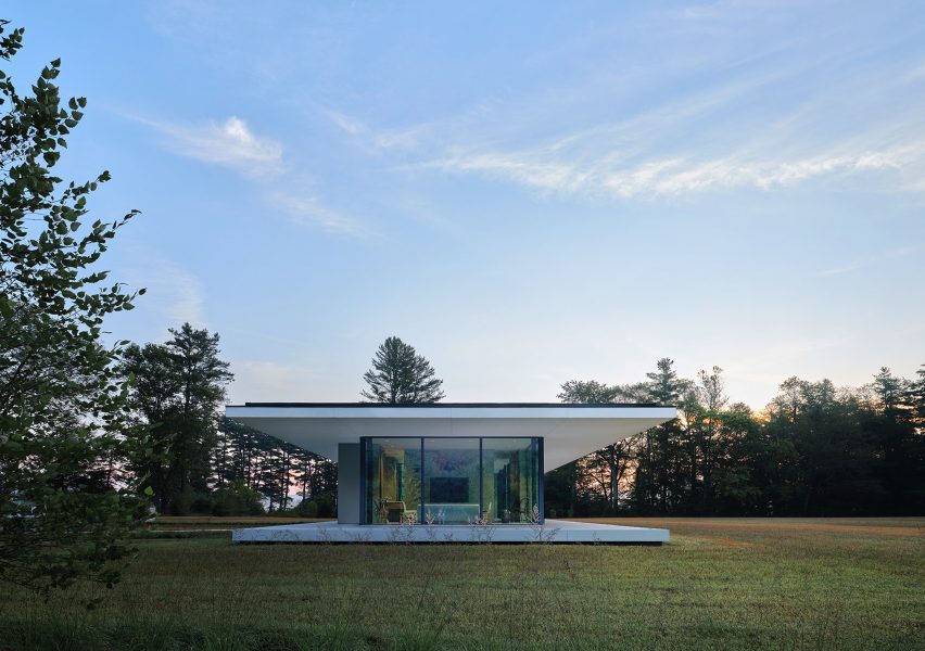 Natural concrete terrace surrounding rectilinear glass house in The Berkshires by Specht Architects