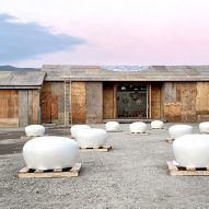 A plywood building on a construction site with white domes in front