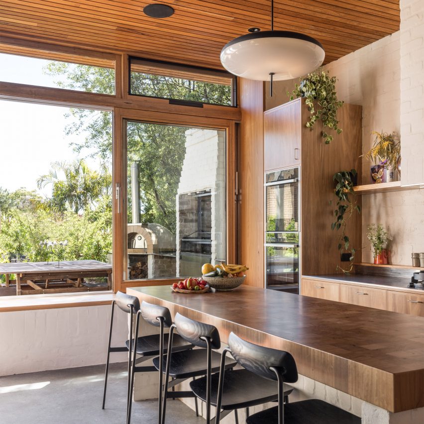 Kitchen with concrete flooring, wood ceiling and a large kitchen island with seating