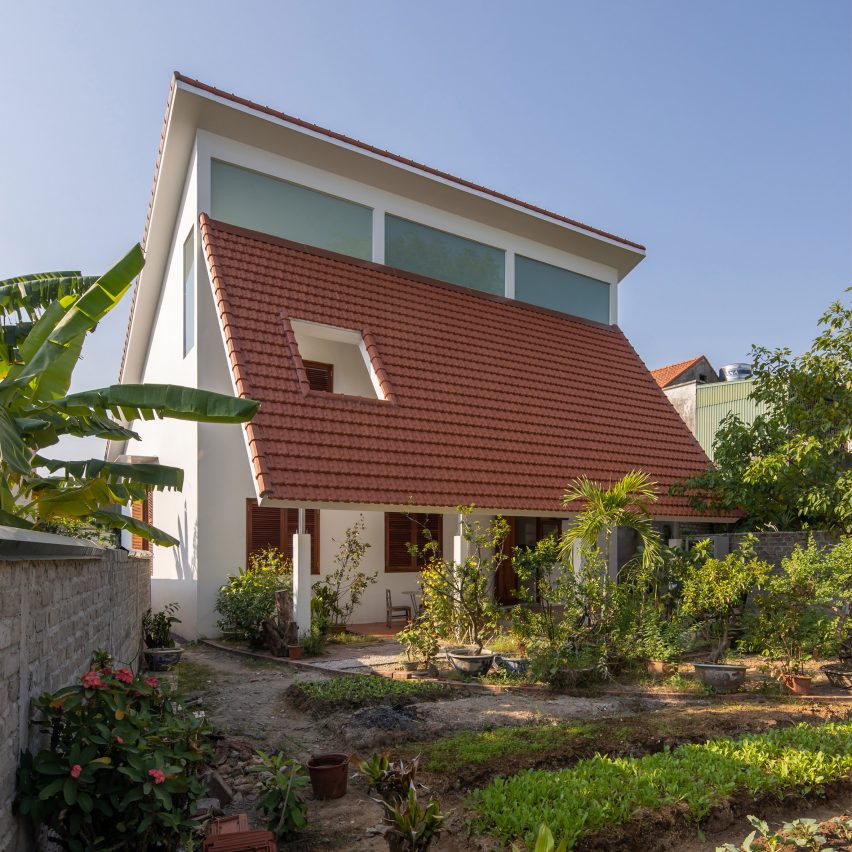 Exterior of a house in Vietnam with a terracotta-tiled roof and planted garden