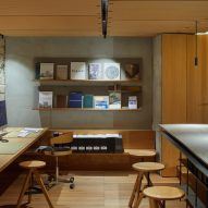 Studio space with wooden flooring, desks, shelves and circular wood swivel seats