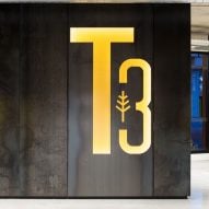Concrete interior space with a yellow T3 logo on the wall