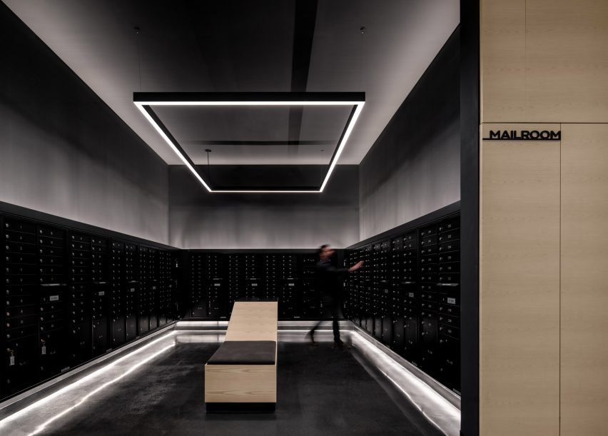 Черно-серебристое почтовое отделение в многофункциональном здании от Handel Architects с прямолинейным светодиодным освещением над головой
